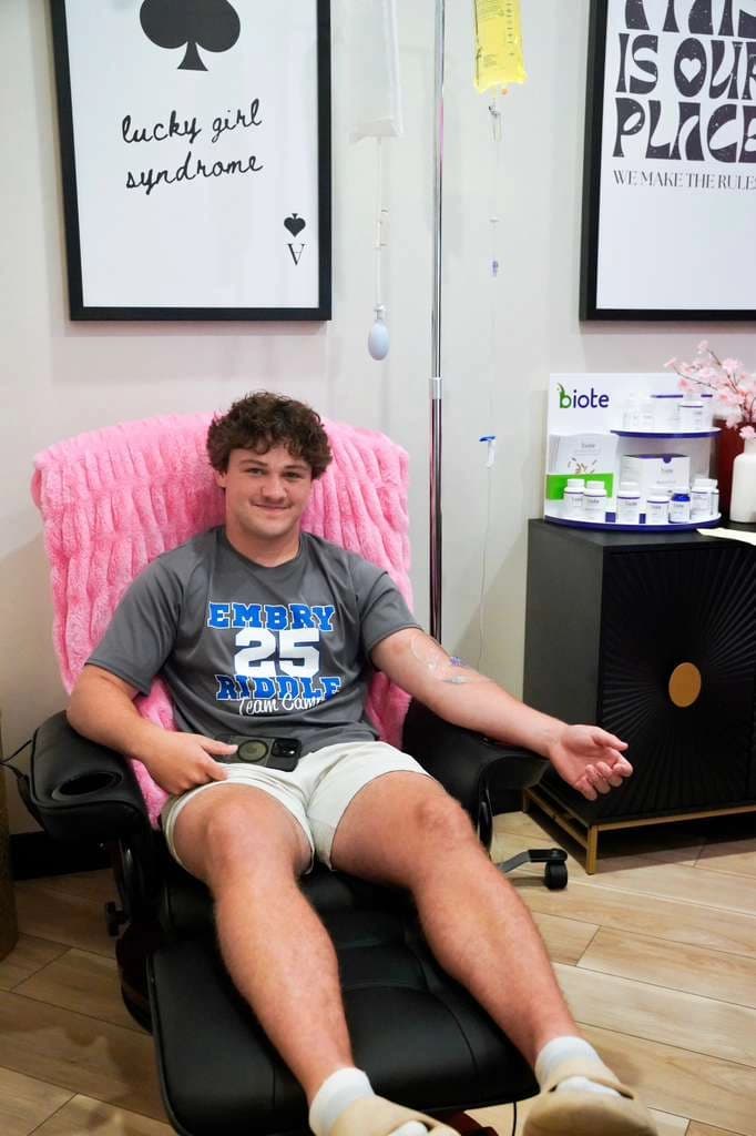 A client seated in the IV therapy chair with a drip line taped to his arm