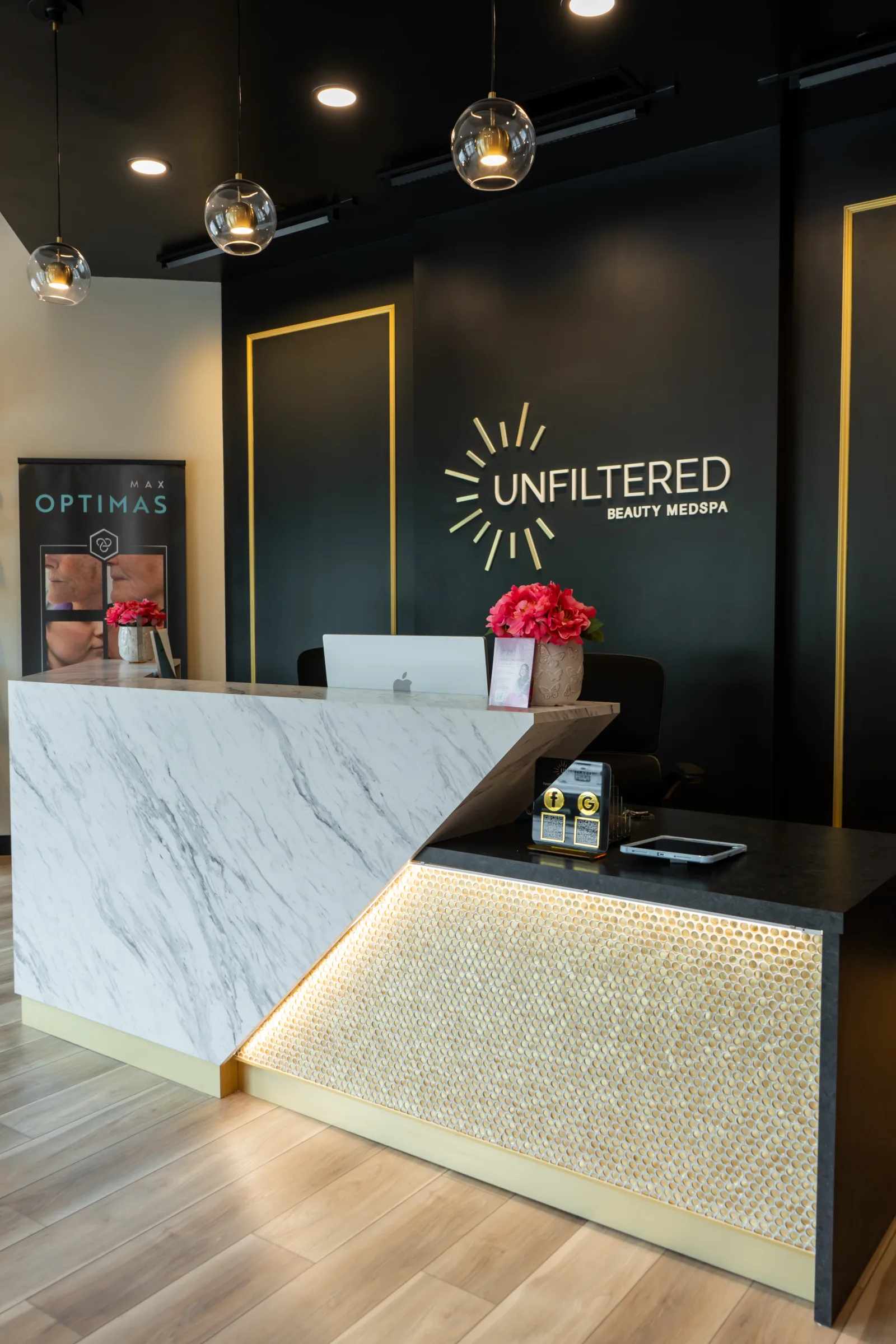 The lit marble reception desk under the gold logo wall